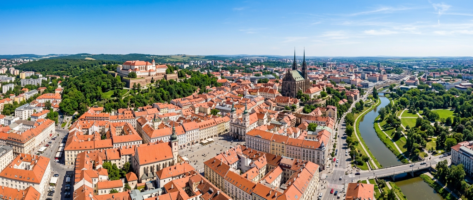 Panoramic aerial view of Brno Czech Republic, red rooftops of historic old town, Spilberk Castle on hilltop, Cathedral of Saints Peter and Paul, green parks, Svratka river, clear sky
