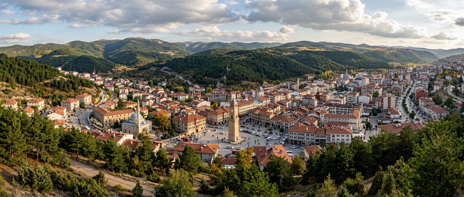 Panoramic view of Yozgat city center in Central Anatolia Turkey, historic Clock Tower visible, Ottoman-era architecture, green pine forests on surrounding hills, Bozok Plateau landscape