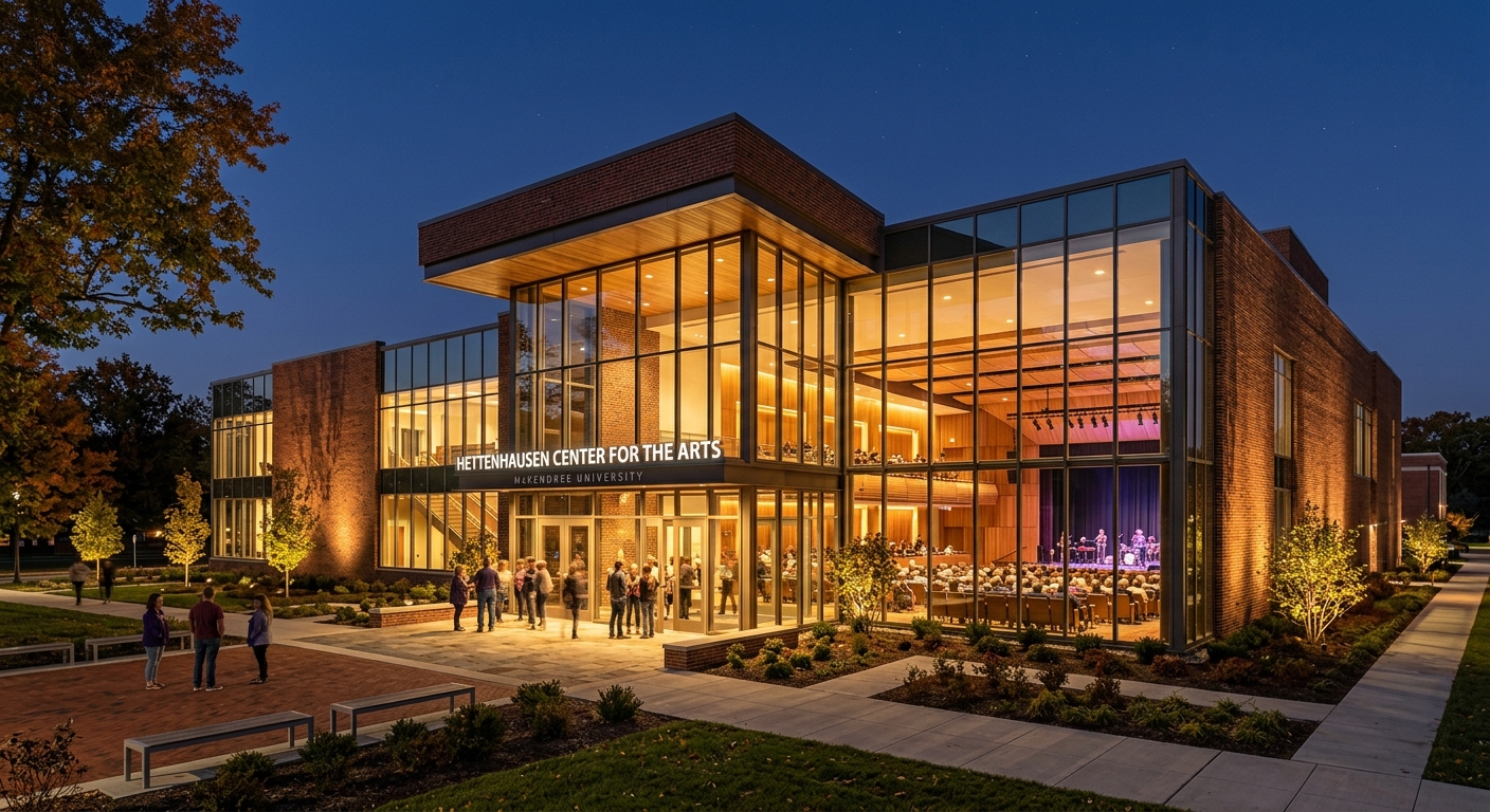 Hettenhausen Center for the Arts at McKendree University, modern performing arts building with glass facade and brick exterior, evening lighting illuminating the entrance, 500-seat auditorium visible through windows