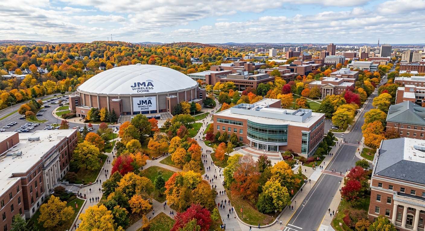 Syracuse University campus aerial view showing the Whitman School of Management building and JMA Wireless Dome surrounded by autumn foliage in Syracuse, New York, with students walking between buildings
