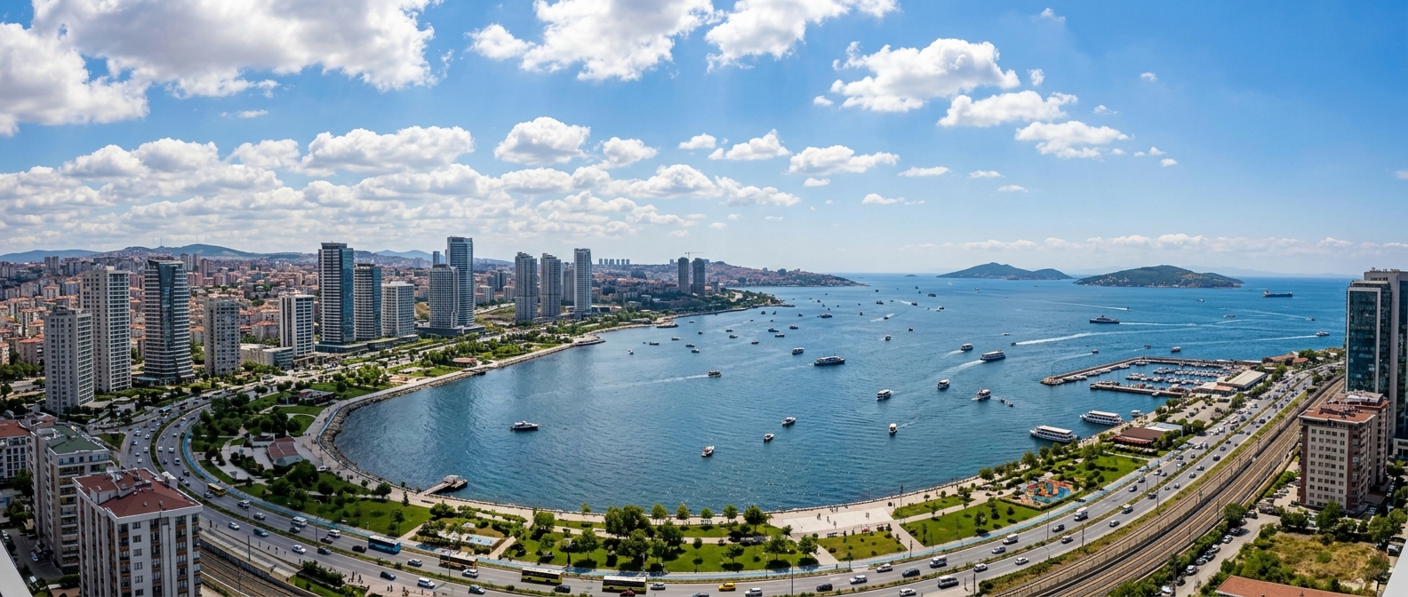 Panoramic view of Kartal district on the Asian side of Istanbul, modern high-rise buildings along the Marmara Sea coastline, Princes Islands visible in the distance, blue sky with scattered clouds